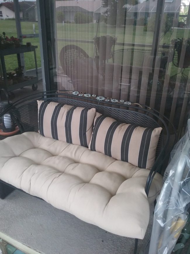 wrought iron settee with cushion and pillows