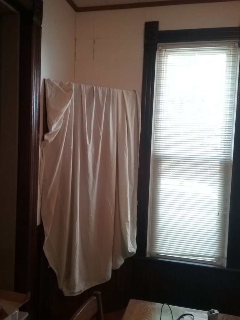 painter's drop cloth over corner cabinet