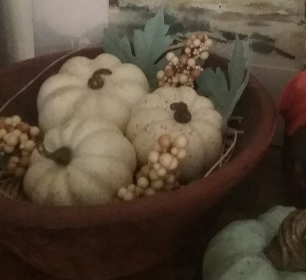 a trio of mini white pumpkins displayed in a handmade bowl