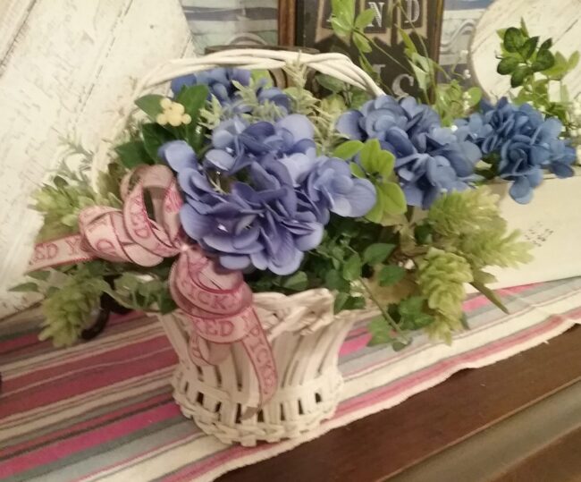Antique basket with blue hydrangea arrangement