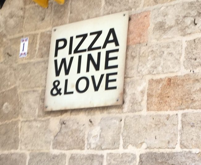 pizza wine love sign on a rustic wall