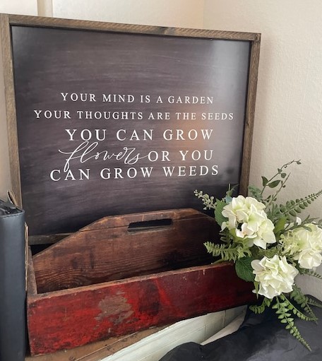 Inspirational quote in a display behind a wooden carrier accented with a bouquet of hydrangea