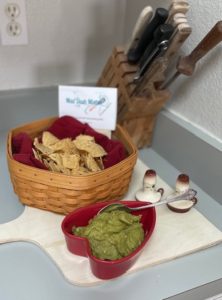 basket of chips with a dish of guacamole