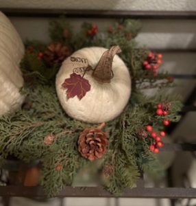 Autumn wreath surrounds a white pumpkin