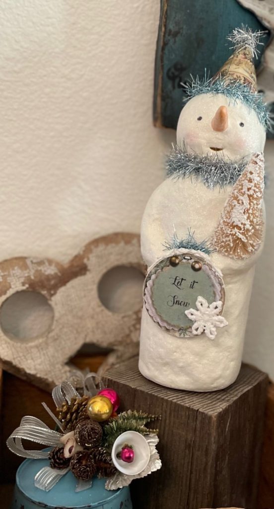 Snowman standing on a piece of barnwood