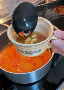 ladling soup into a mug