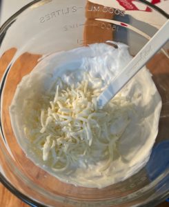 glass mixing bowl with shredded cheese, mayo & sour cream