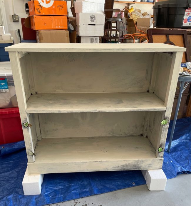 dark stained bookshelf with one coat of chalk paint