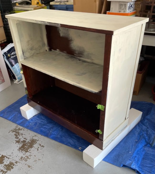 Old Ochre Chalk paint being used on a dark stained bookcase