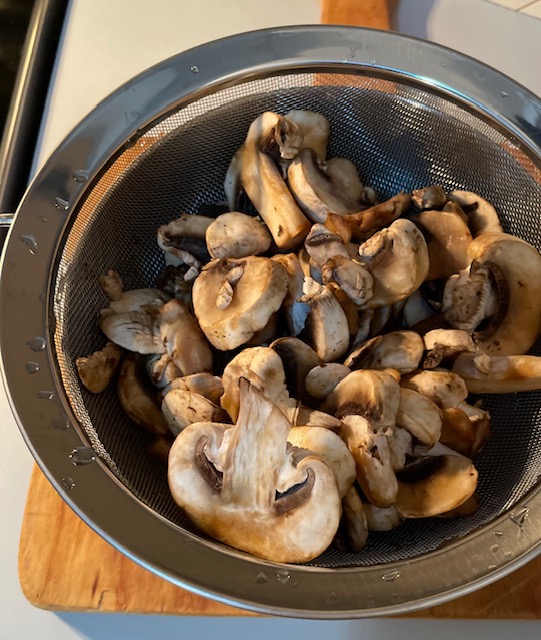 sliced mushrooms in a strainer