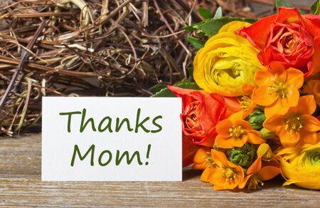 orange flowers with a thanks mom card