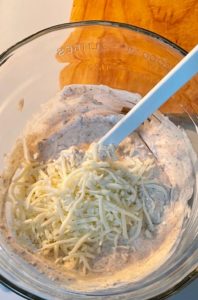 shredded cheese being added to Chipotle Bacon dip