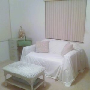 old white sheet as a slipcover for a loveseat