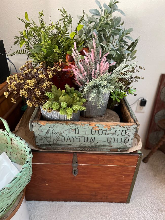 Faux Flowers displayed in buckets inside an old box
