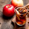 wooden cutting board with mulling spices and apple cider