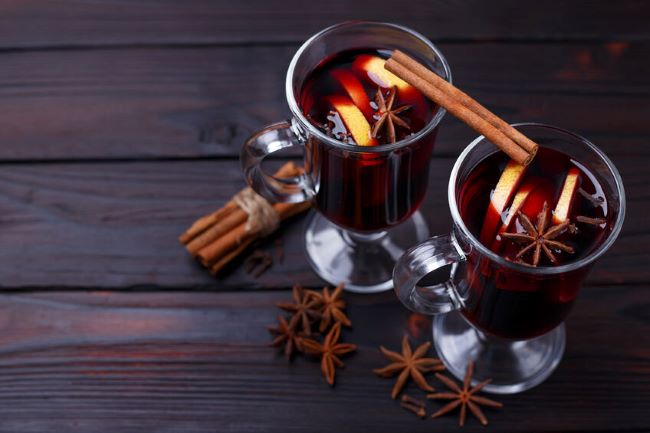 glass mugs of mulled cider with cinnamon sticks and star anise