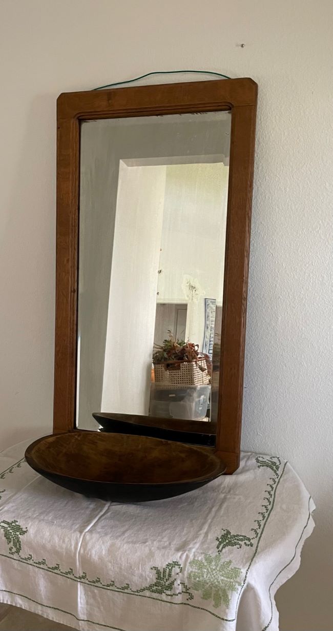 oval dough bowl in front of mirror in entryway