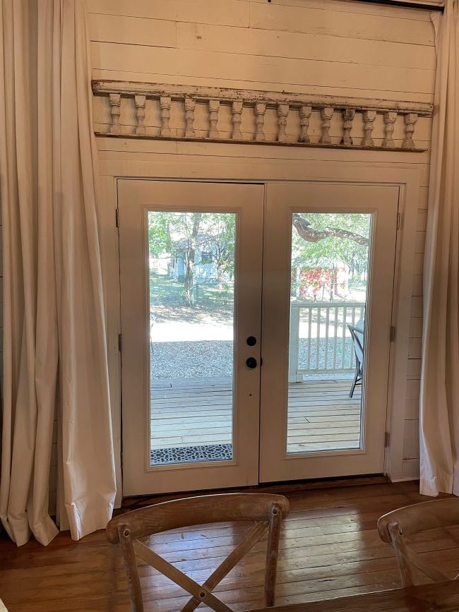 French doors with old porch railing displayed above them
