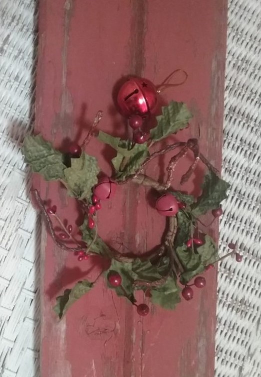 piece of barnwood with a berry ring and a jingle bell