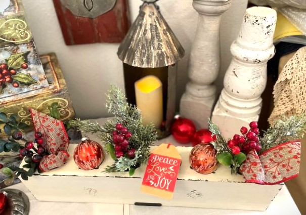 close up of white sugar mold, red ornaments, berries and ribbon