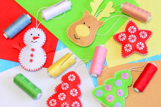 brightly colored spools of embroidery floss, pieces of felt and assorted Christmas ornaments