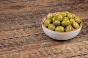 marinated green olives in a small white bowl