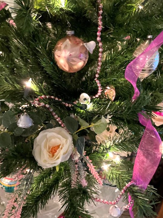 artificial Christmas tree with pink ornaments, hot pink ribbon and silk roses