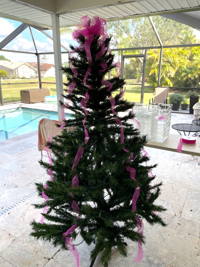 artificial Christmas tree with hot pink ribbon streamers & bow