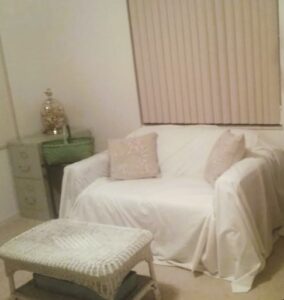 small loveseat draped with a sheet