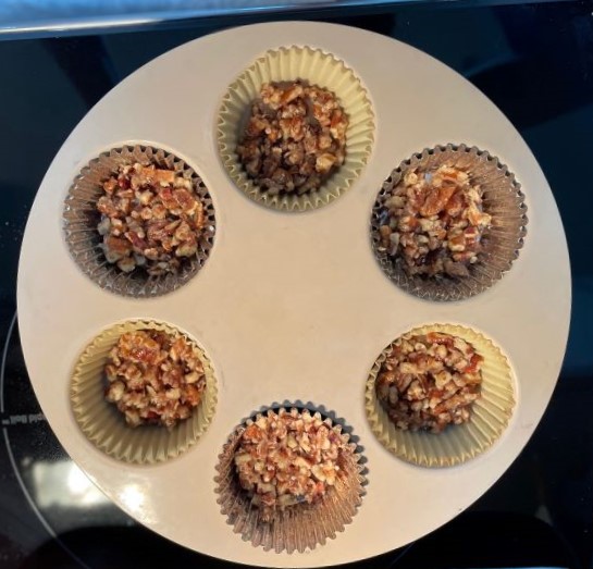 6 cupcake liners with pecan crust , ready to fill