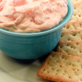 small bowl of shrimp dip on a plate with crackers