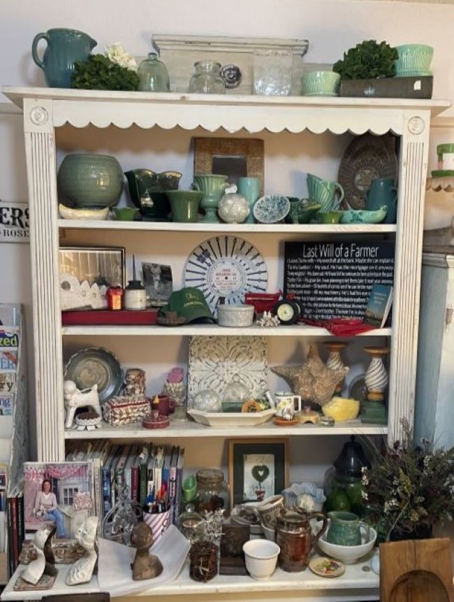 Vintage pottery in shades of celadon green displayed in a bookcase