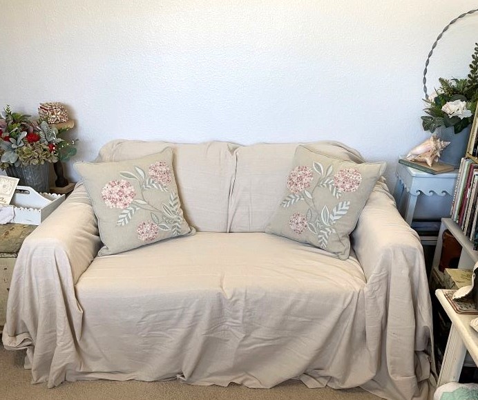 dropcloth covered loveseat accented with throw pillows