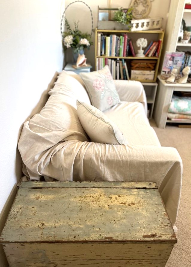 drop cloth covered loveseat seen from doorway