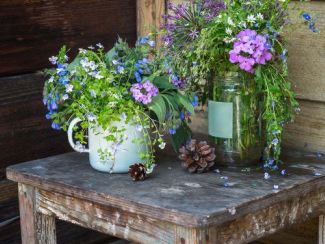 two bouquets of wild flowers displayed on a rustic table