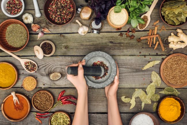 woman grinding pepper with a mortar & pestle