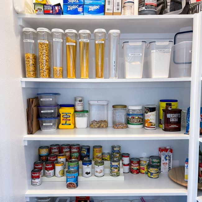 pantry shelves with canned foods, staples stored in clear containers