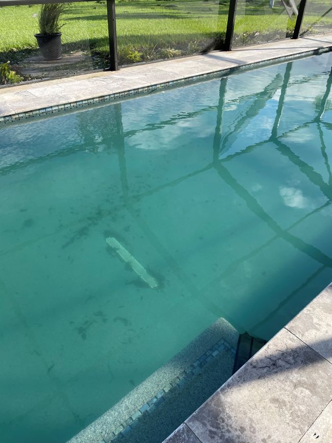 inground pool with silt and debris after a hurricane