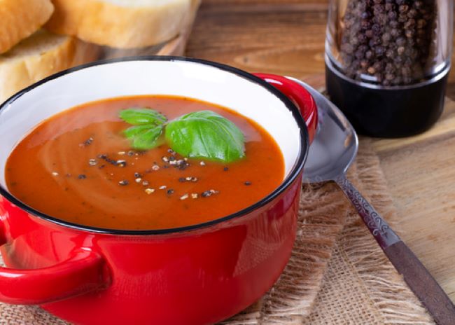 red enamel soup mug filled with tomato soup