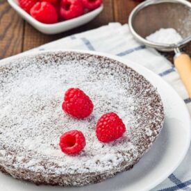 Chocolate cake baked in a round pan. Confectioner's sugar sprinkled on top
