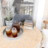 lace covered table with two chairs and Iced tea on a porch