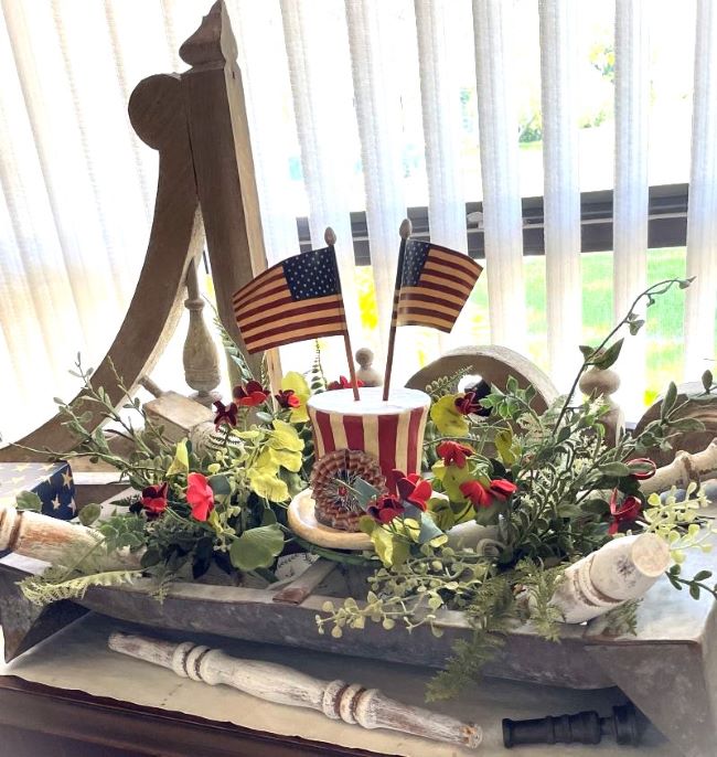 patriotic inspired centerpiece in a galvanized hog feeder