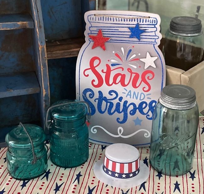 a trio of vintage mason jars accented with a cardboard Stars & Stripes sign
