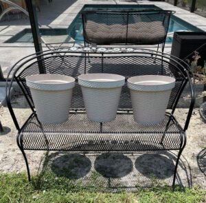 three cream colored 12 inch eco friendly containers lined up on a patio chair