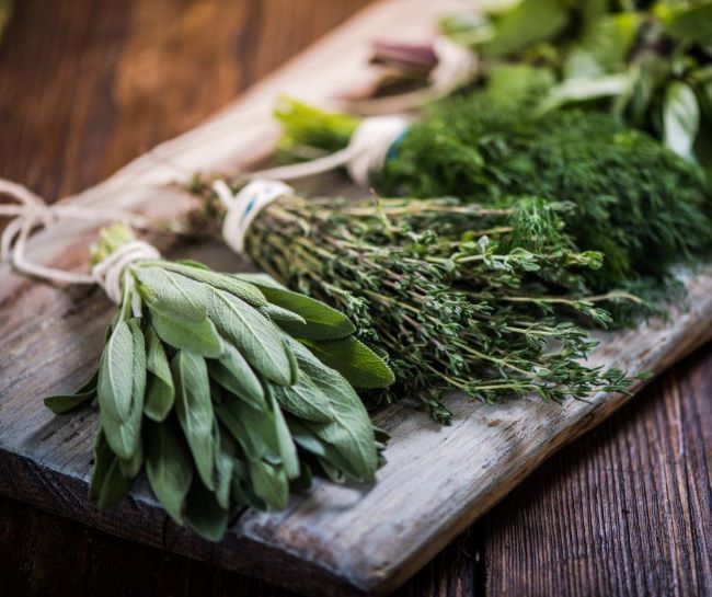 bundles of assorted herbs laying on a wood plank