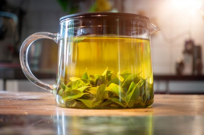 glass tea pot with lemon verbena leaves steeping in it