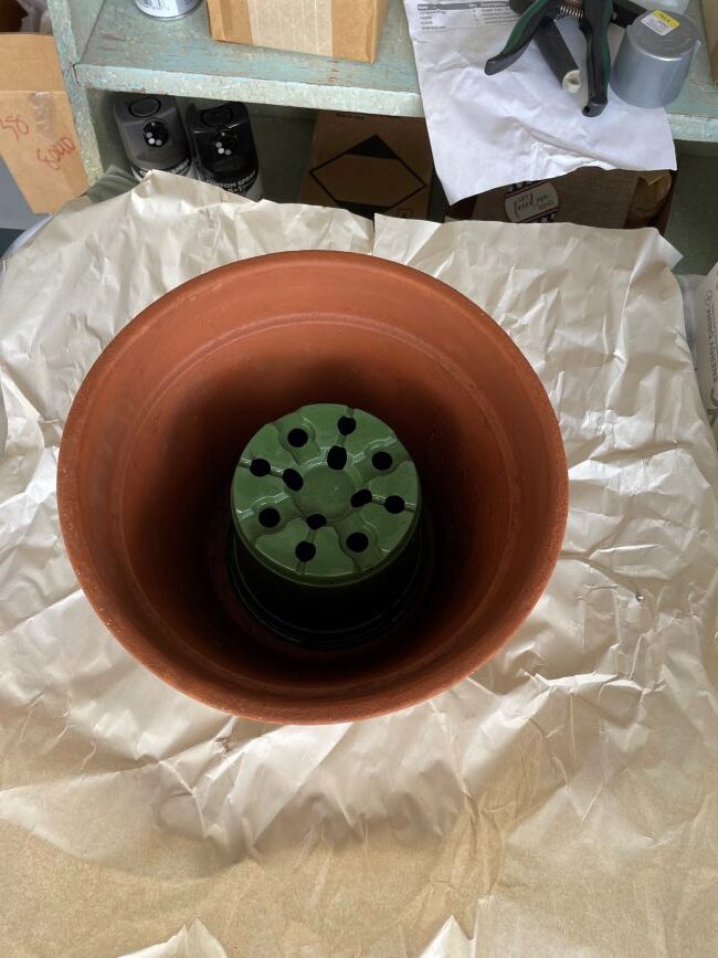 inverted plastic pot inside a terra cotta pot