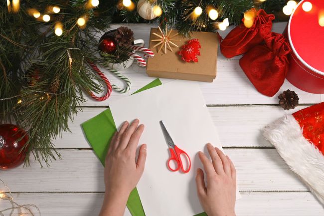 wood background with scissors, sheets of paper and candy canes