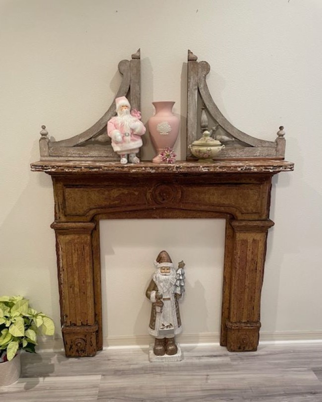 Fireplace mantel decorated with flea market style items in pastel colors