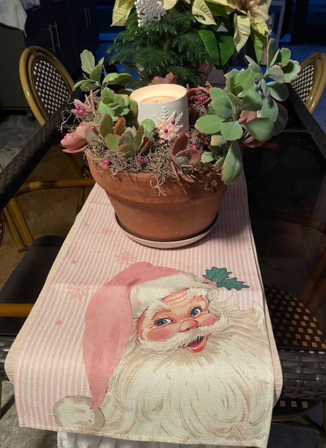 snowflake succulent centerpiece on a holiday table with a pink Santa runner